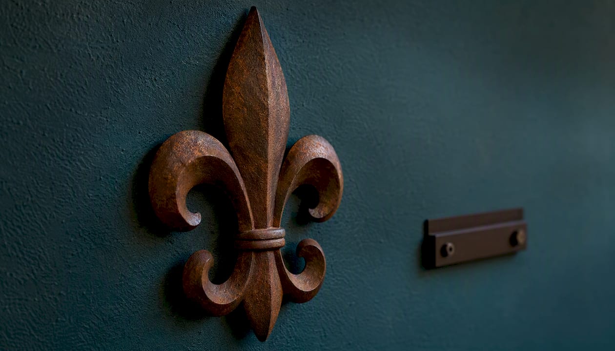 Artisan metal fleur de lis plaque close-up