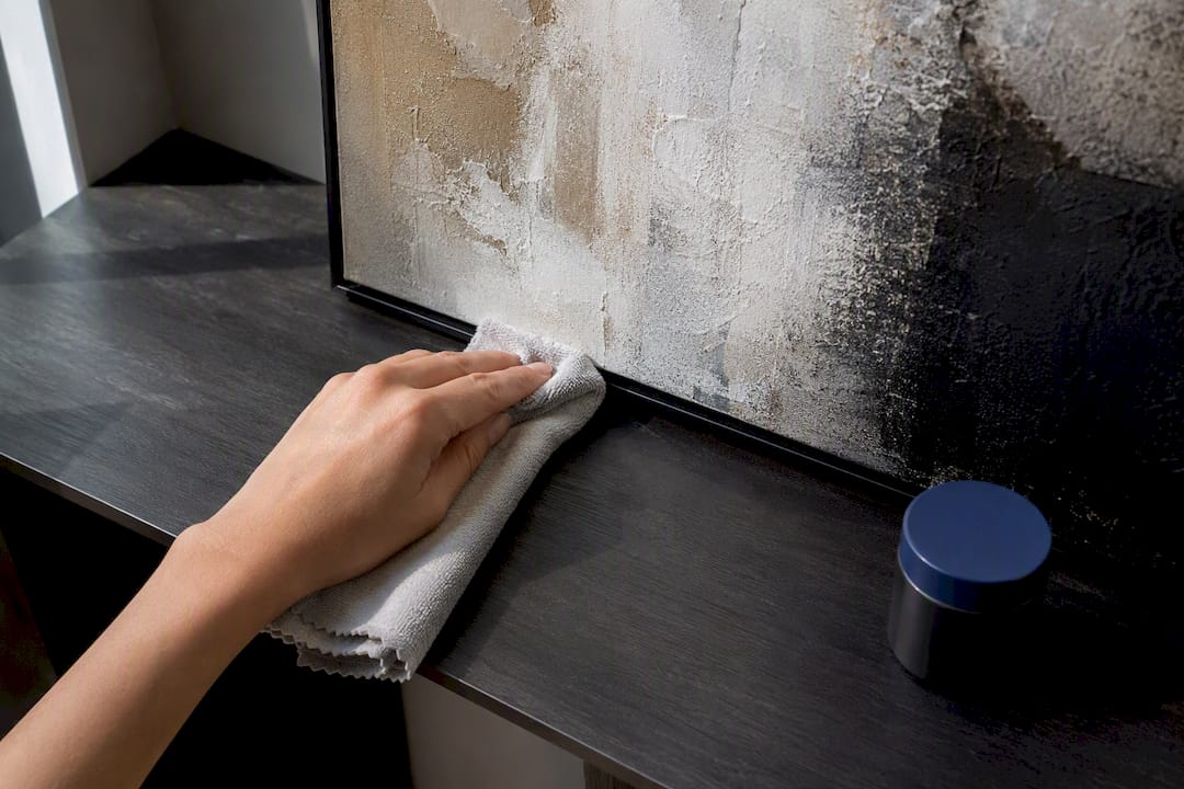 Hand dusting canvas with microfiber cloth