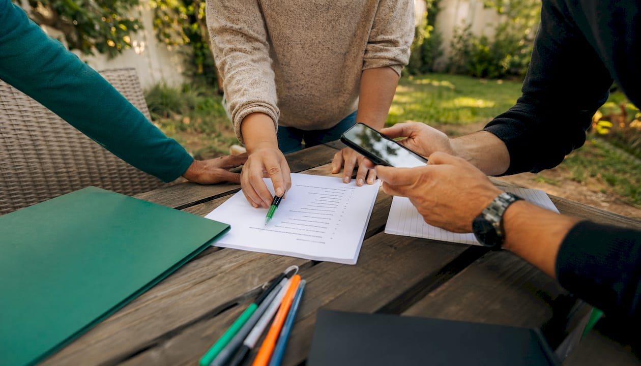 Hands organizing home inspection materials on table