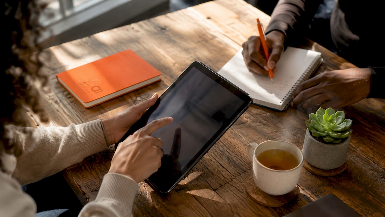 Close-up of hands accessing public datasets on devices in café