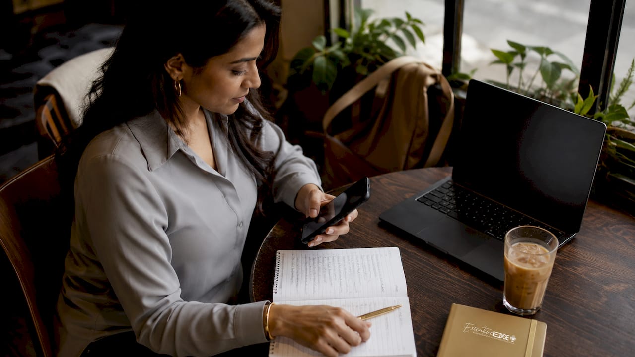 Executive woman multitasking on smartphone and laptop