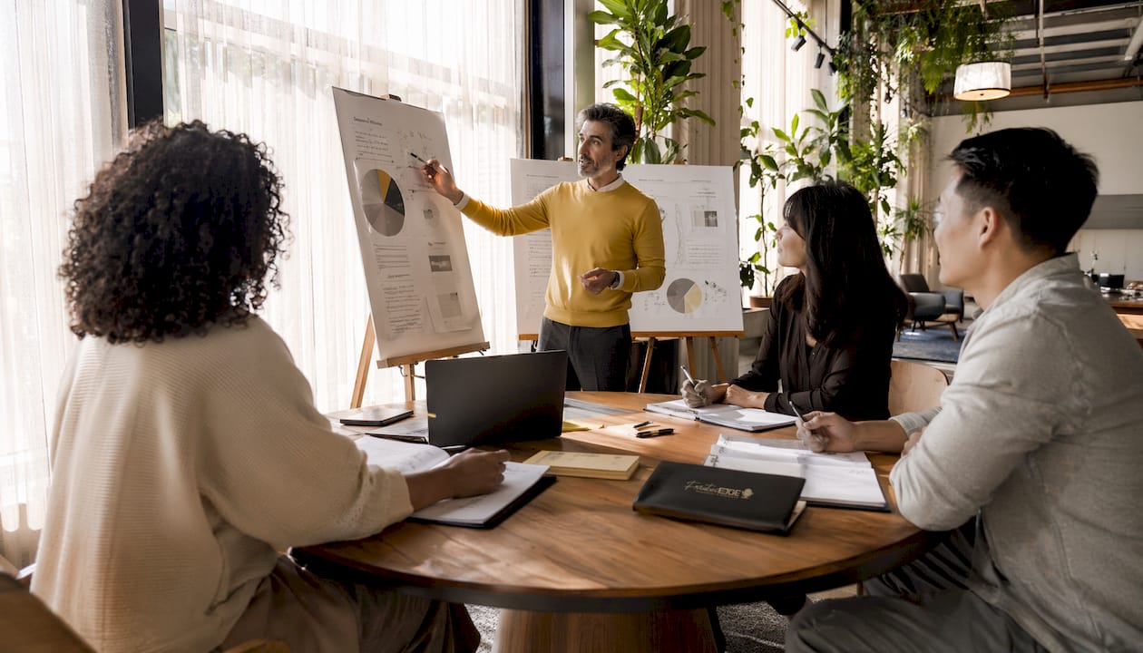 Consultant discussing strategies with clients in meeting room
