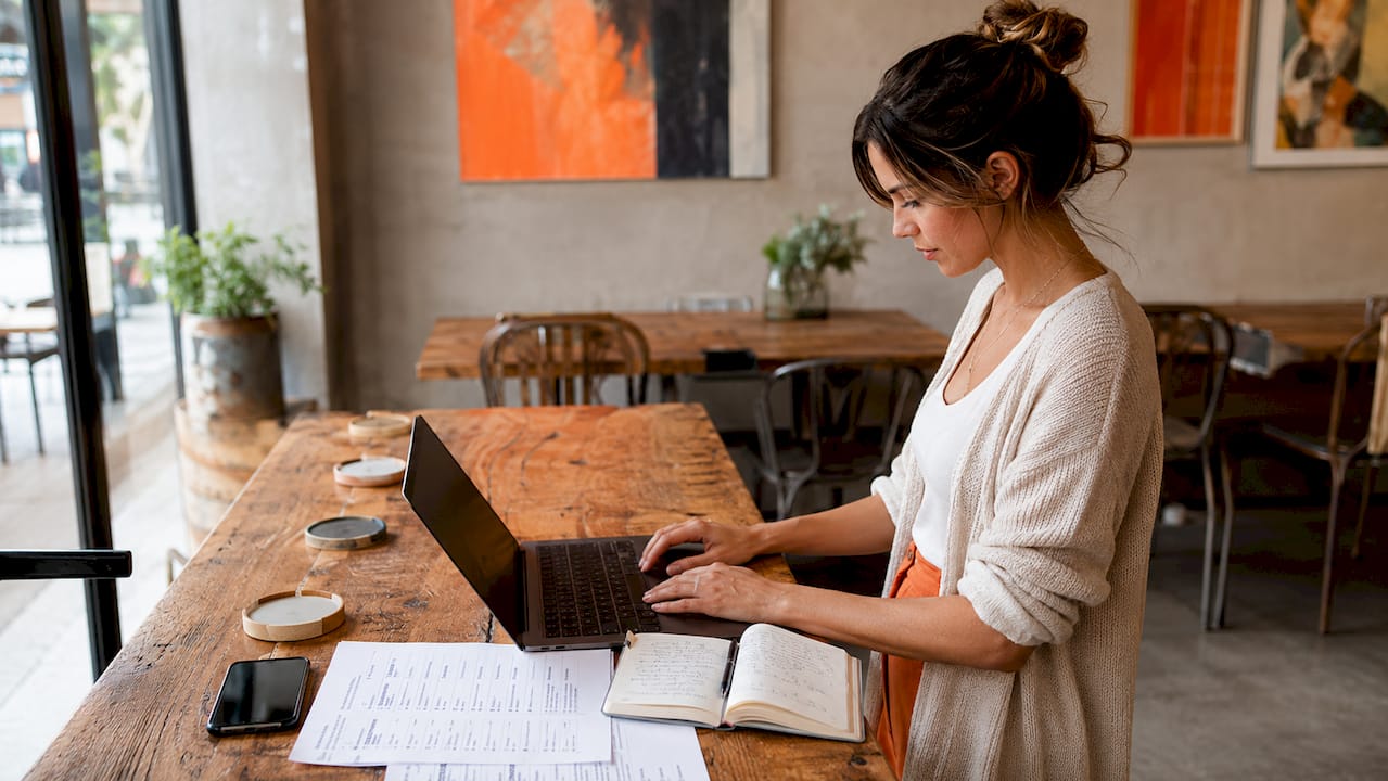 Hands auditing CRM data on laptop at desk