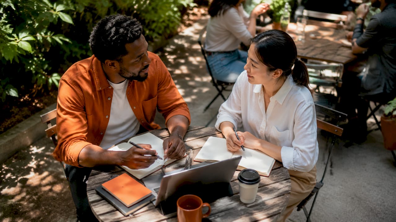 Consultants discussing kickoff meeting at café table