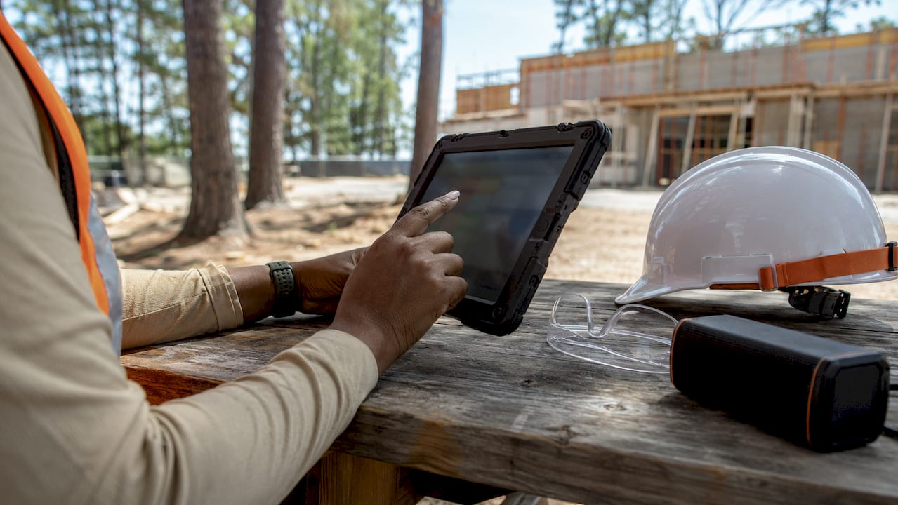 Field supervisor using tablet on construction site