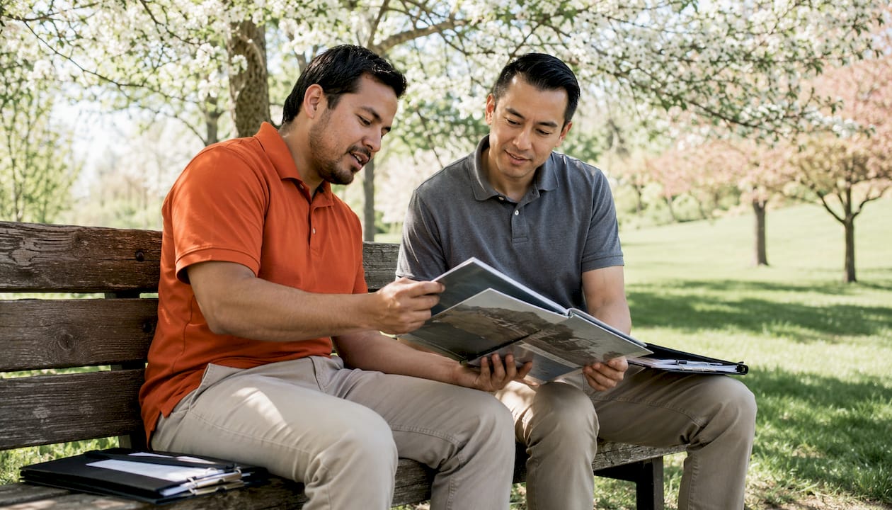 Two men reviewing contractor references outdoors