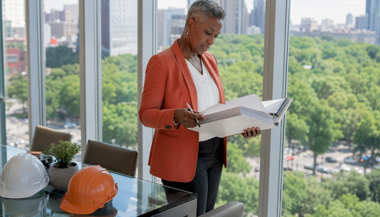 Operations director reviewing project documents in office
