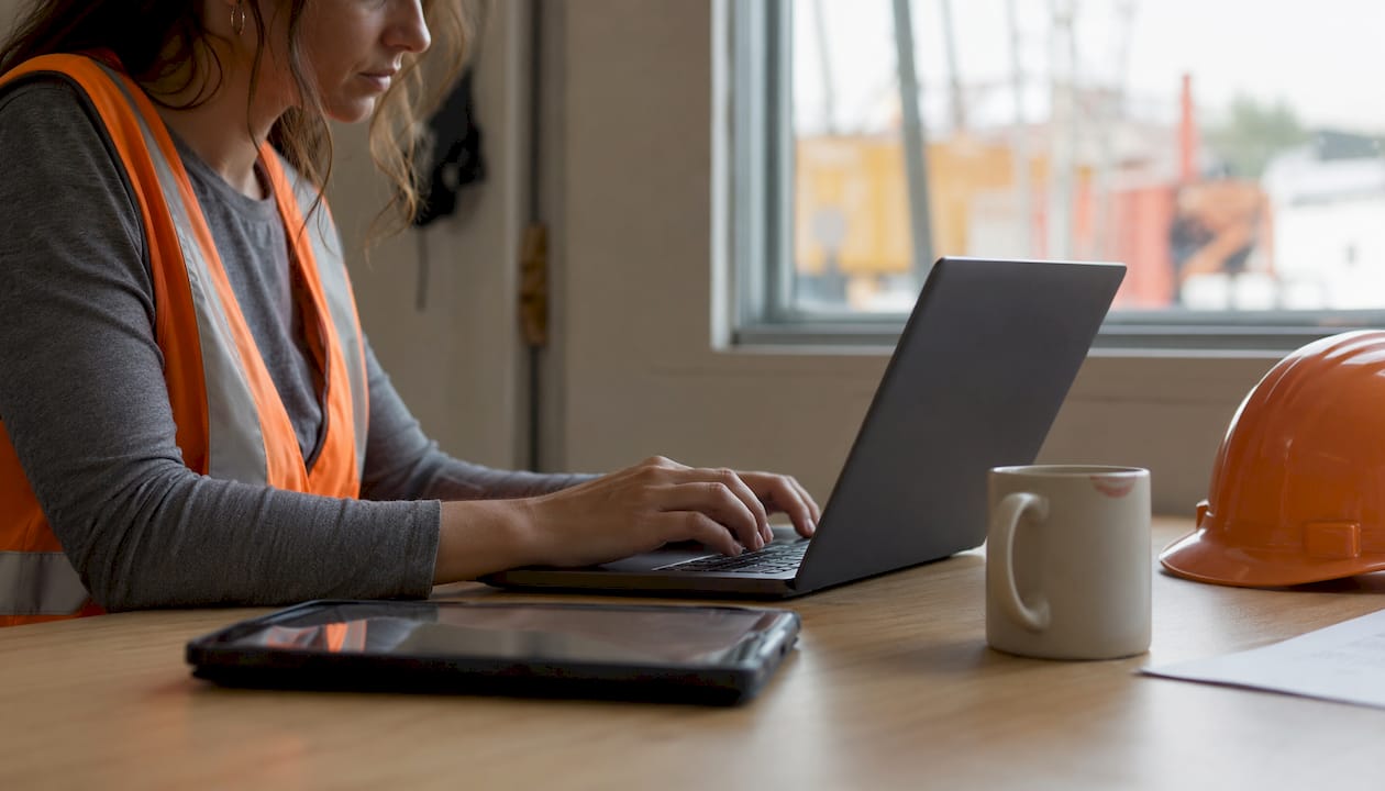 Contractor customizing report software on laptop
