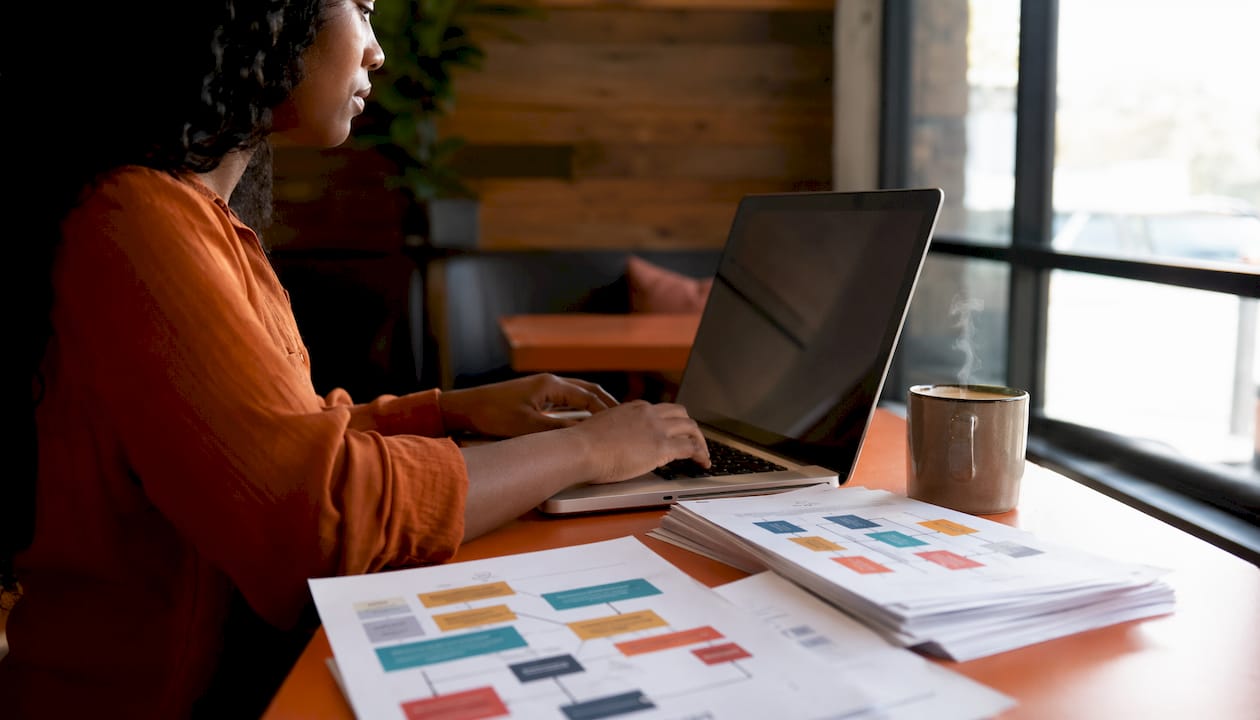 Hands typing near construction CRM documents