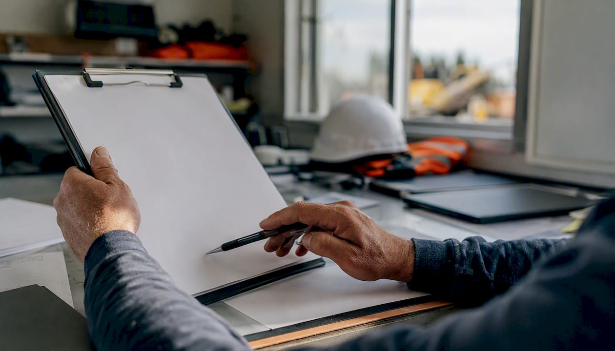 Hands inspecting bond paperwork at construction site