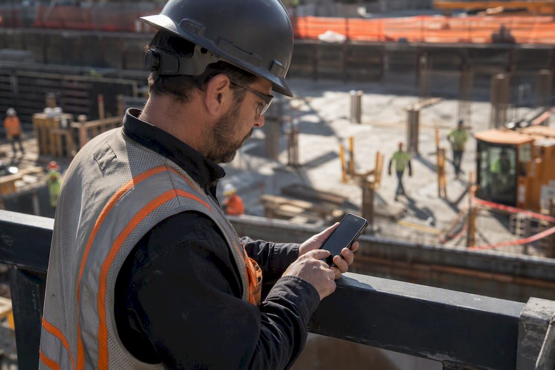 Construction worker using mobile device outdoors