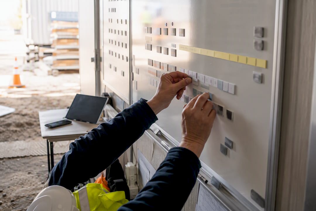 Worker hands setting up project code board