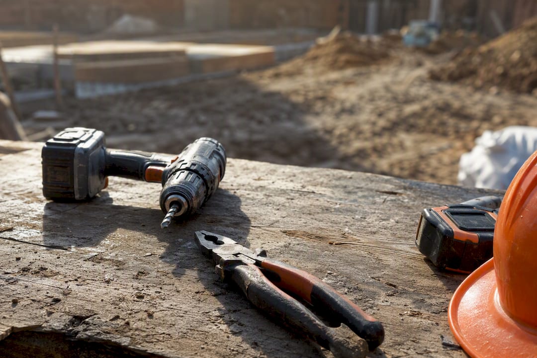 Rugged construction tools on dusty workbench