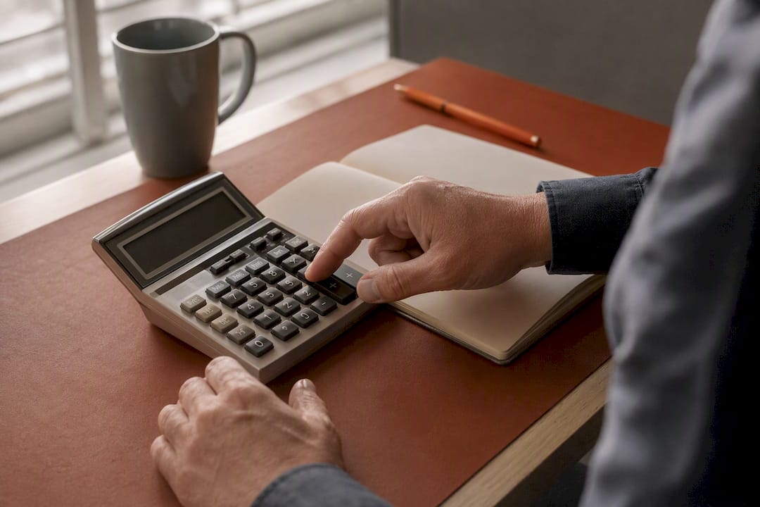 Hands calculating recruiter fees on calculator