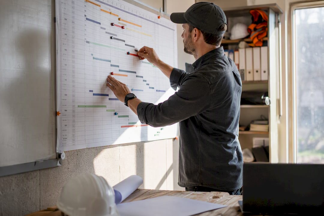 Scheduler adjusting construction schedule chart on site