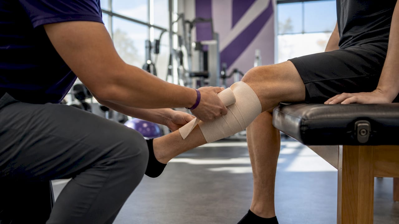 Healthcare professional applying compression bandage to leg