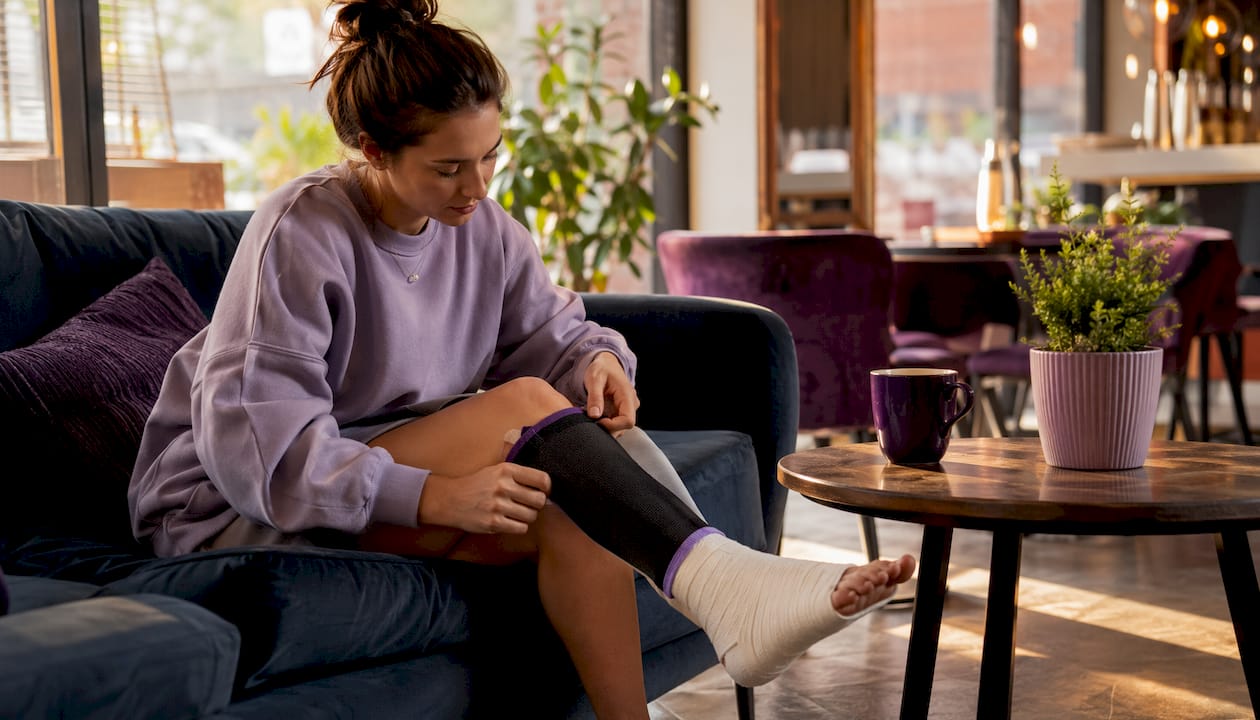 Woman dressing with leg cast adaptive leggings