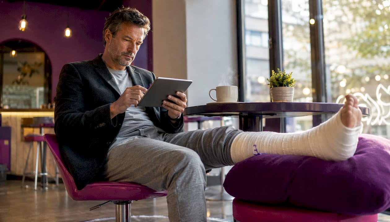 Man in professional outfit with leg cast