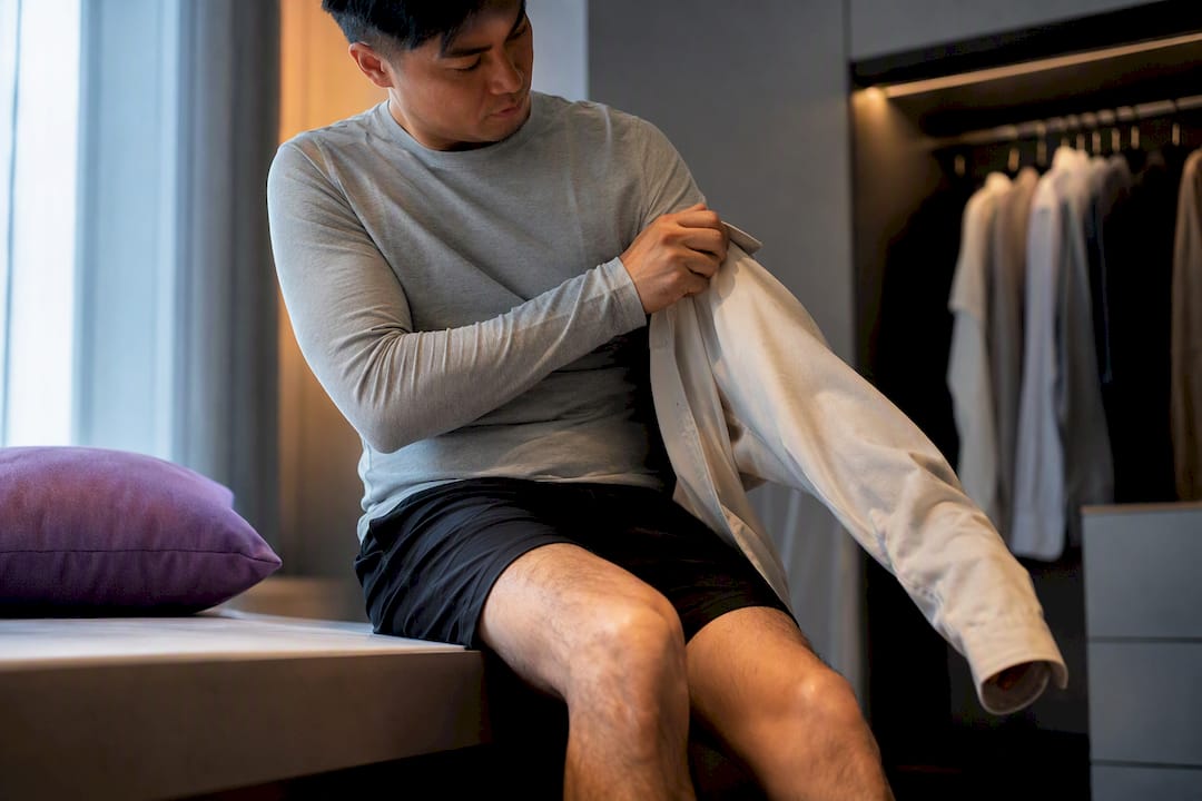 Person dressing one handed on a bench