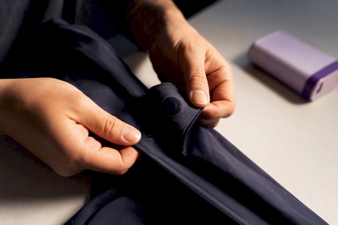 Hands examining a concealed magnetic garment closure