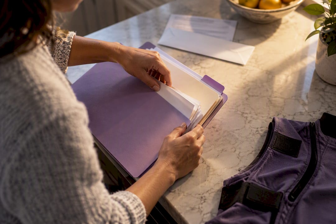 Caregiver organizing adaptive clothing claim paperwork