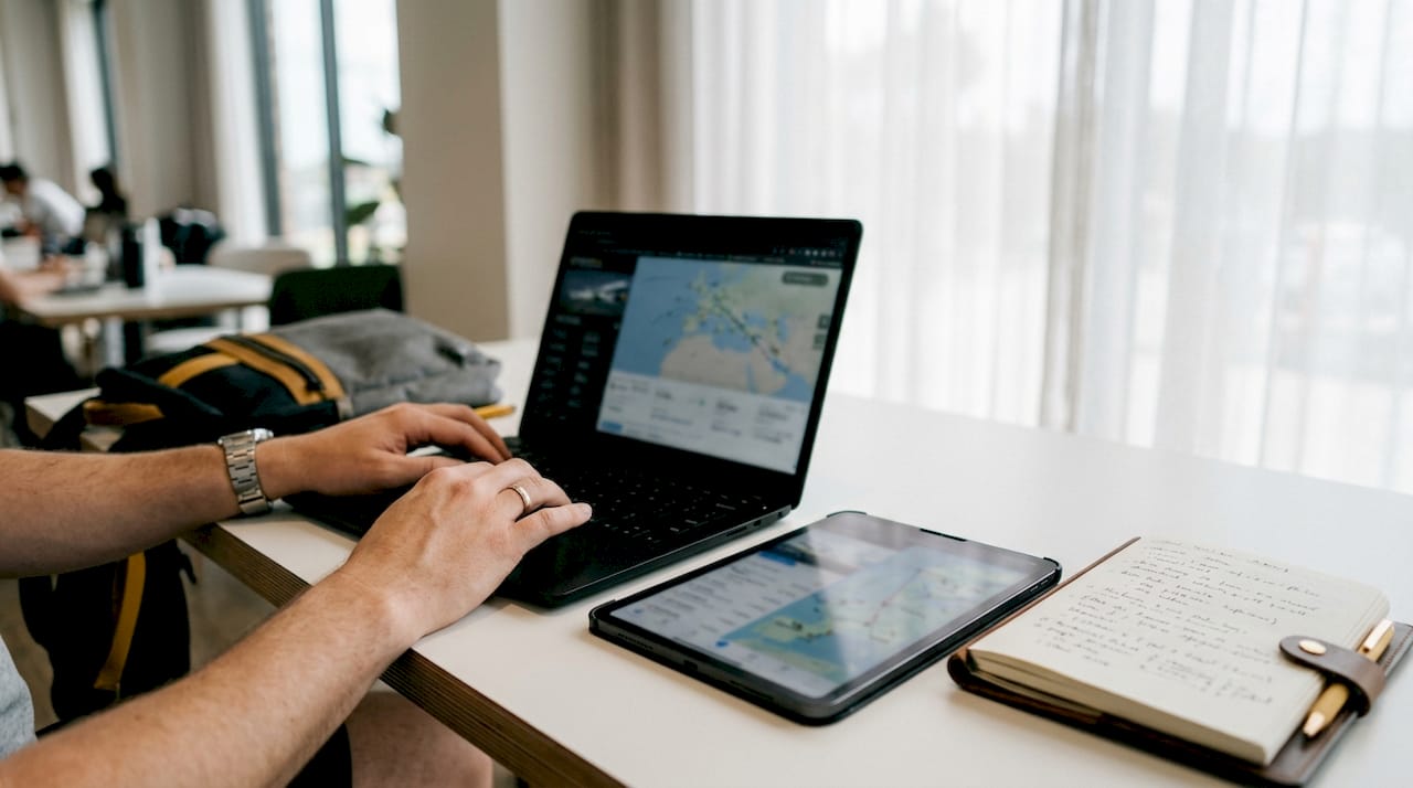 Hands typing flight tracking data on keyboard
