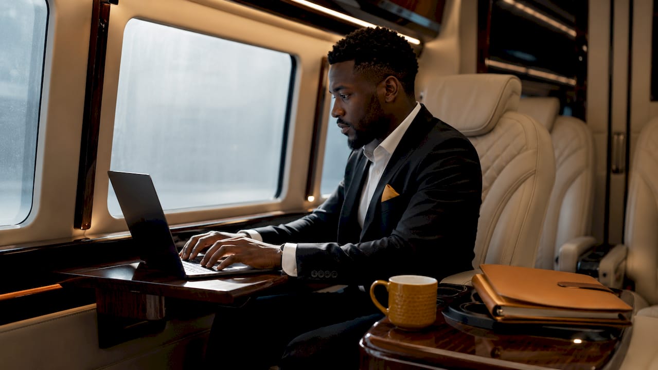 Professional working on laptop inside executive Sprinter van