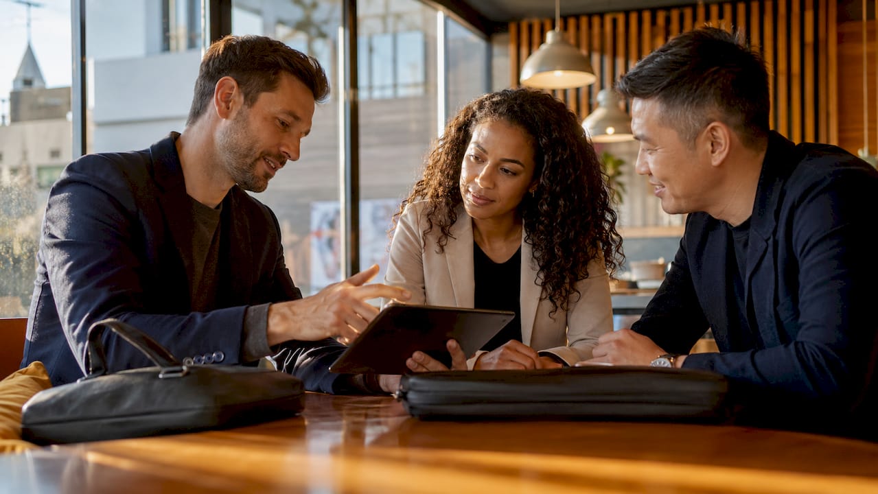 Professionals discussing ground transportation options on tablet