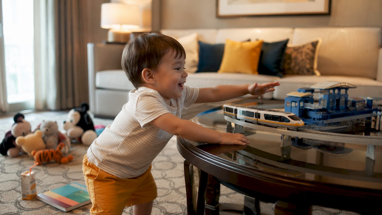 Child playing with toy monorail in hotel room
