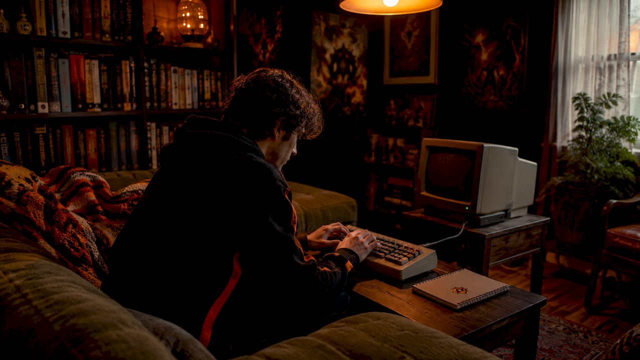 Person engaging with text adventure game at desk