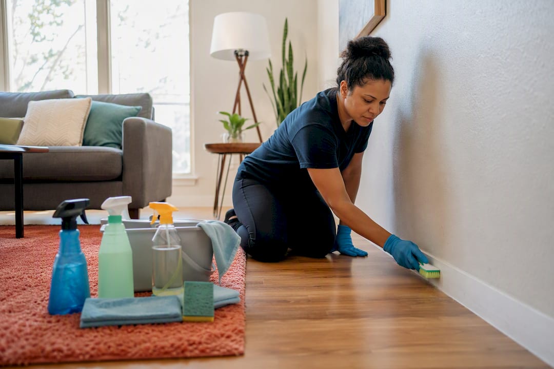 Cleaner wiping mirror in rental bedroom