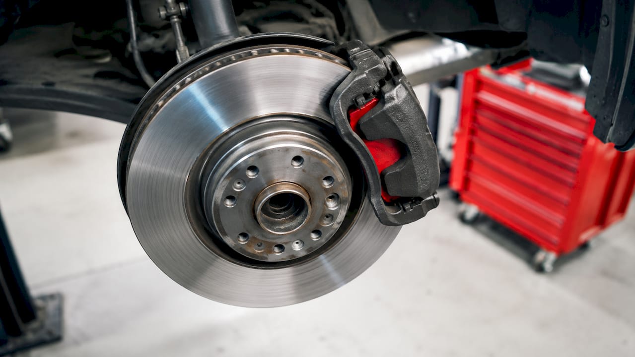 Close-up of brake caliper compressing brake rotor