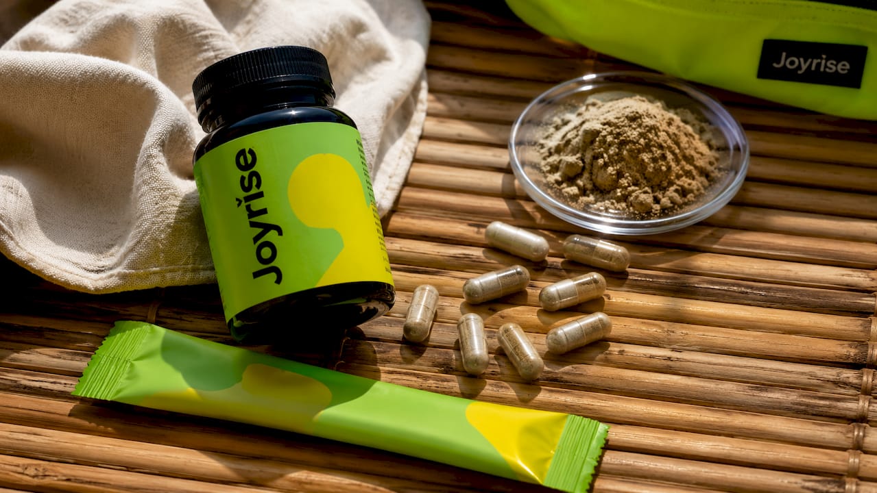 Joyrise DHM capsule bottle and stick pack flat lay on stone