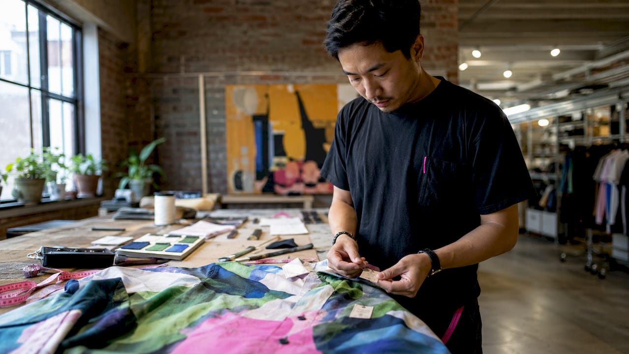 Hands inspecting certified sustainable streetwear garment