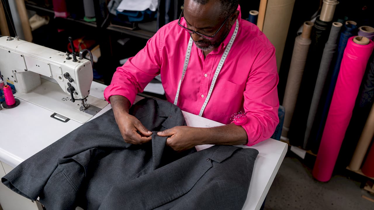Hands tailoring jacket sleeve in workshop
