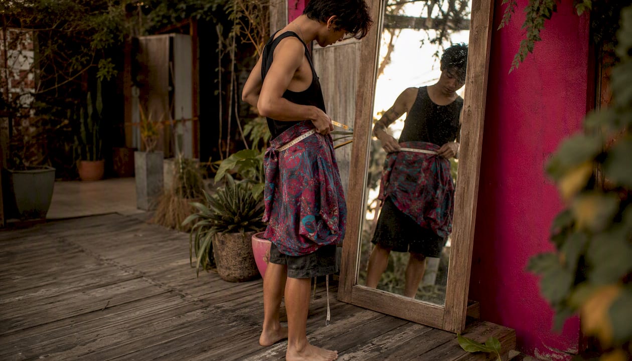 Person using mirror to measure waist solo