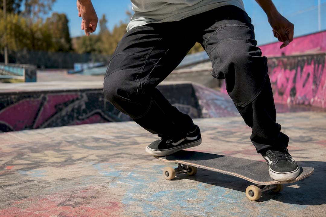 Skateboarder crouching in gusseted pants