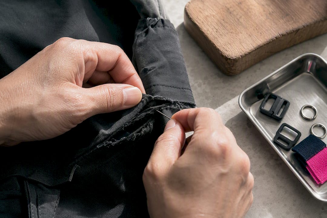 Tailor patching a torn garment seam