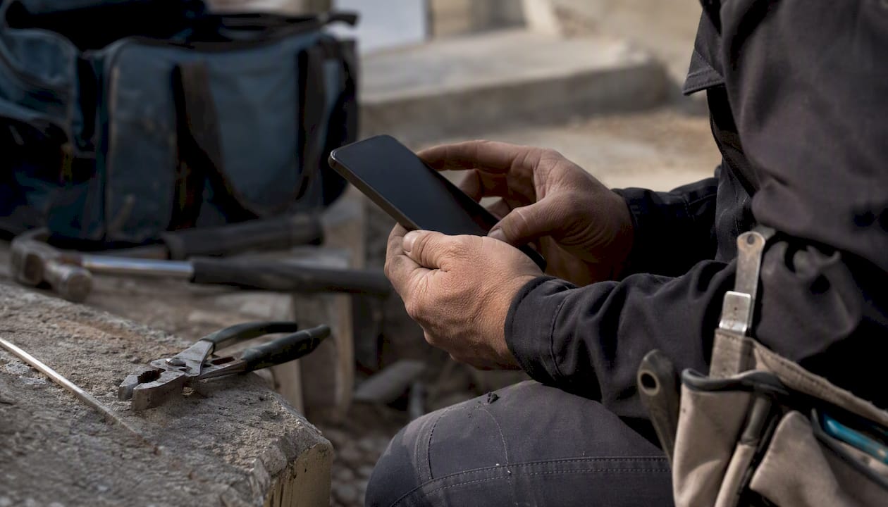 Hands managing mobile device in field workbench