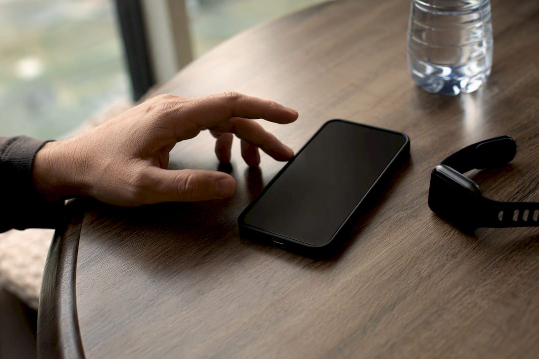 Hand hovering above phone, pausing to reply
