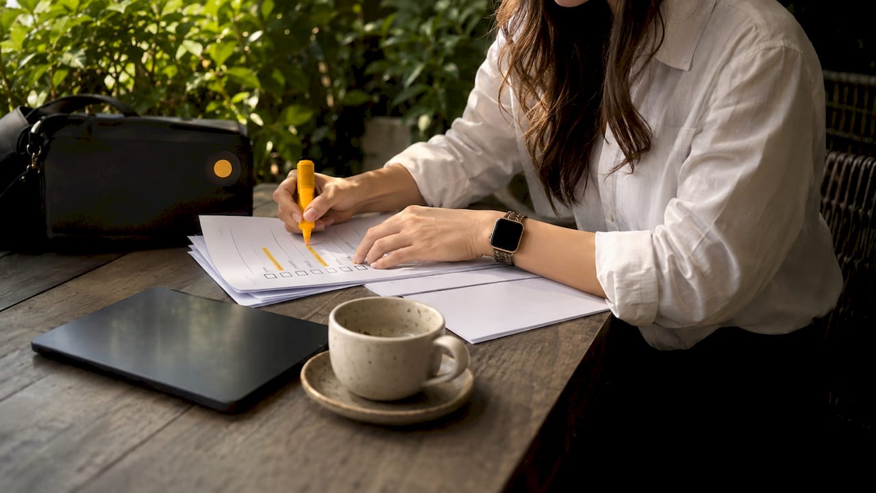 Hands organizing prospect research checklist
