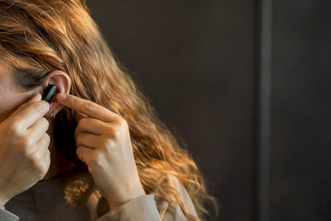Hands adjusting wireless earpiece