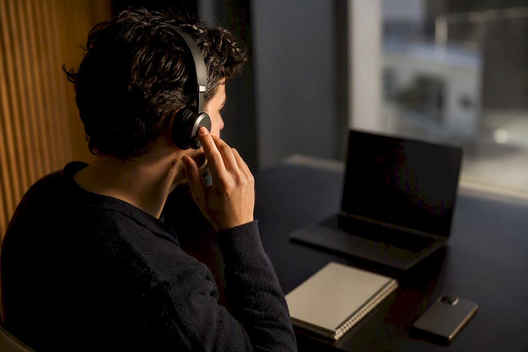 Hand holding headset in a sales coaching setting