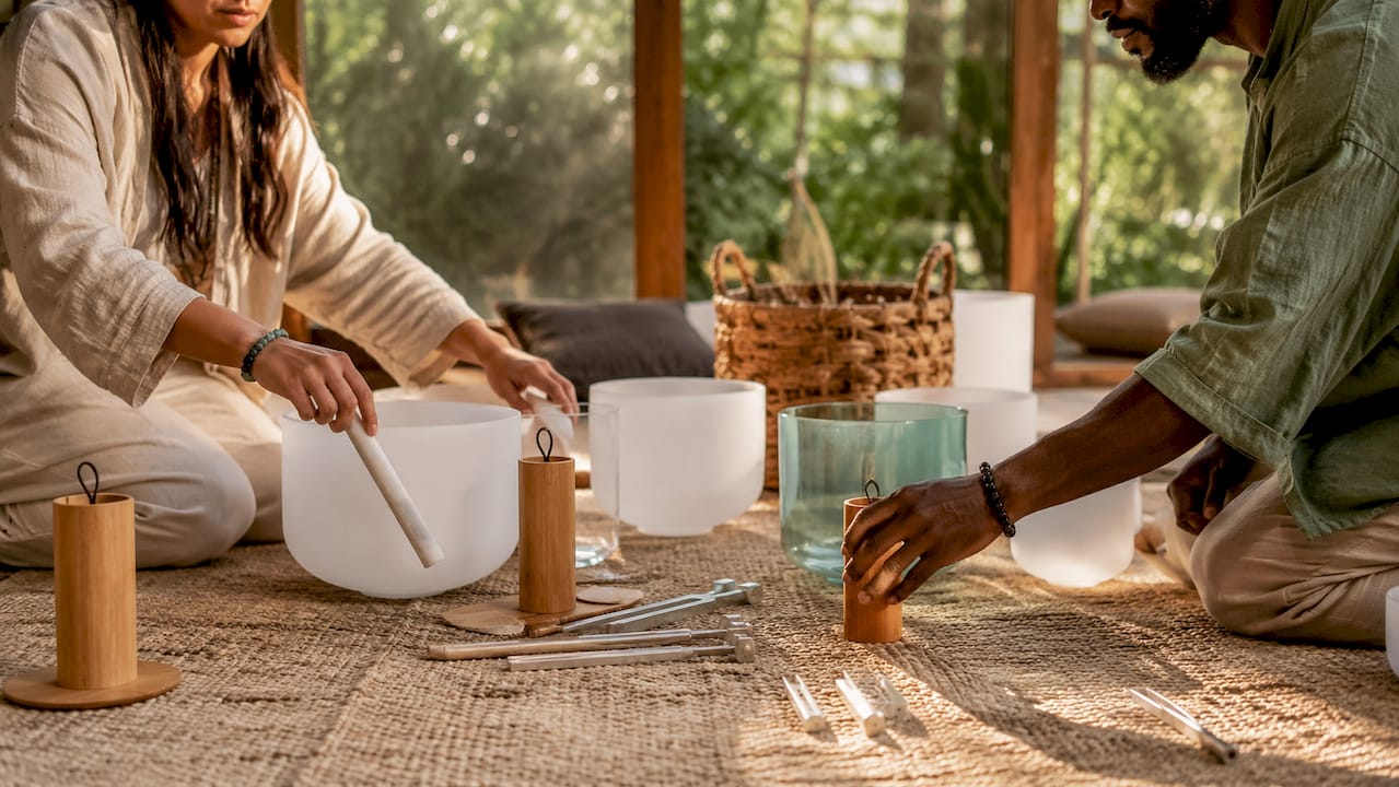 Hands arranging sound healing instruments