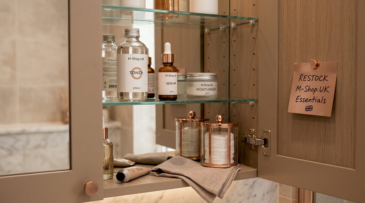 Open bathroom cabinet with arranged skincare products