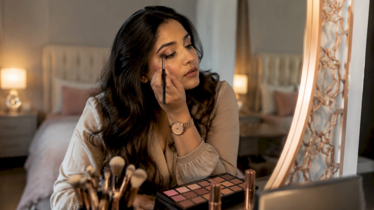 Woman applying eyeshadow with makeup kit