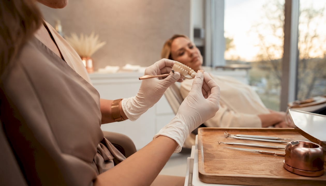 Dentist holding polishing tools near teeth model