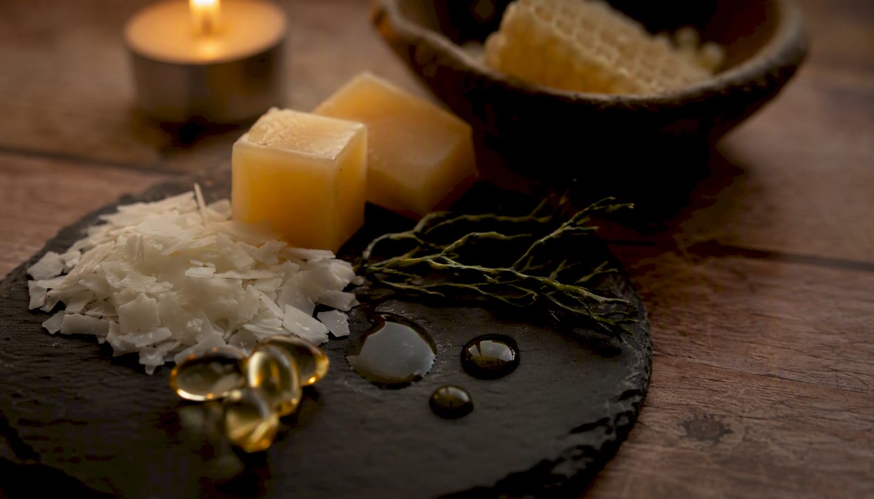 Close-up of natural lip balm ingredients on linen