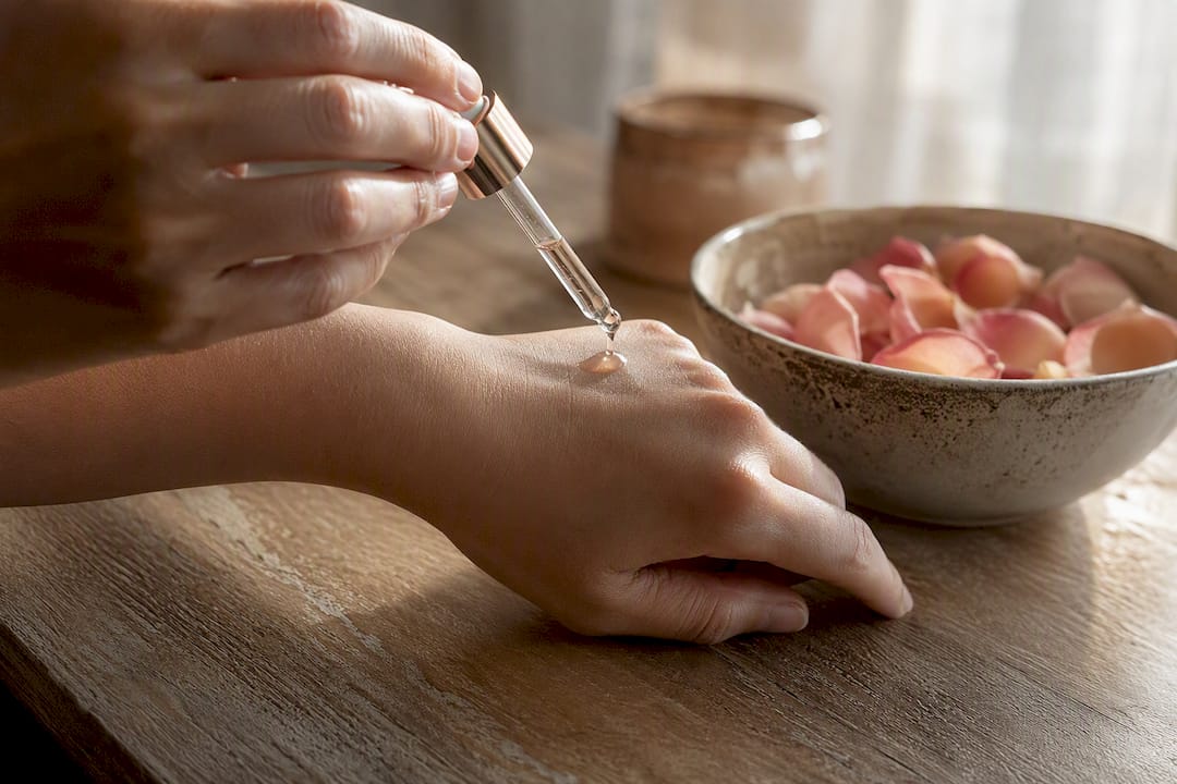 Hands applying hyaluronic acid serum