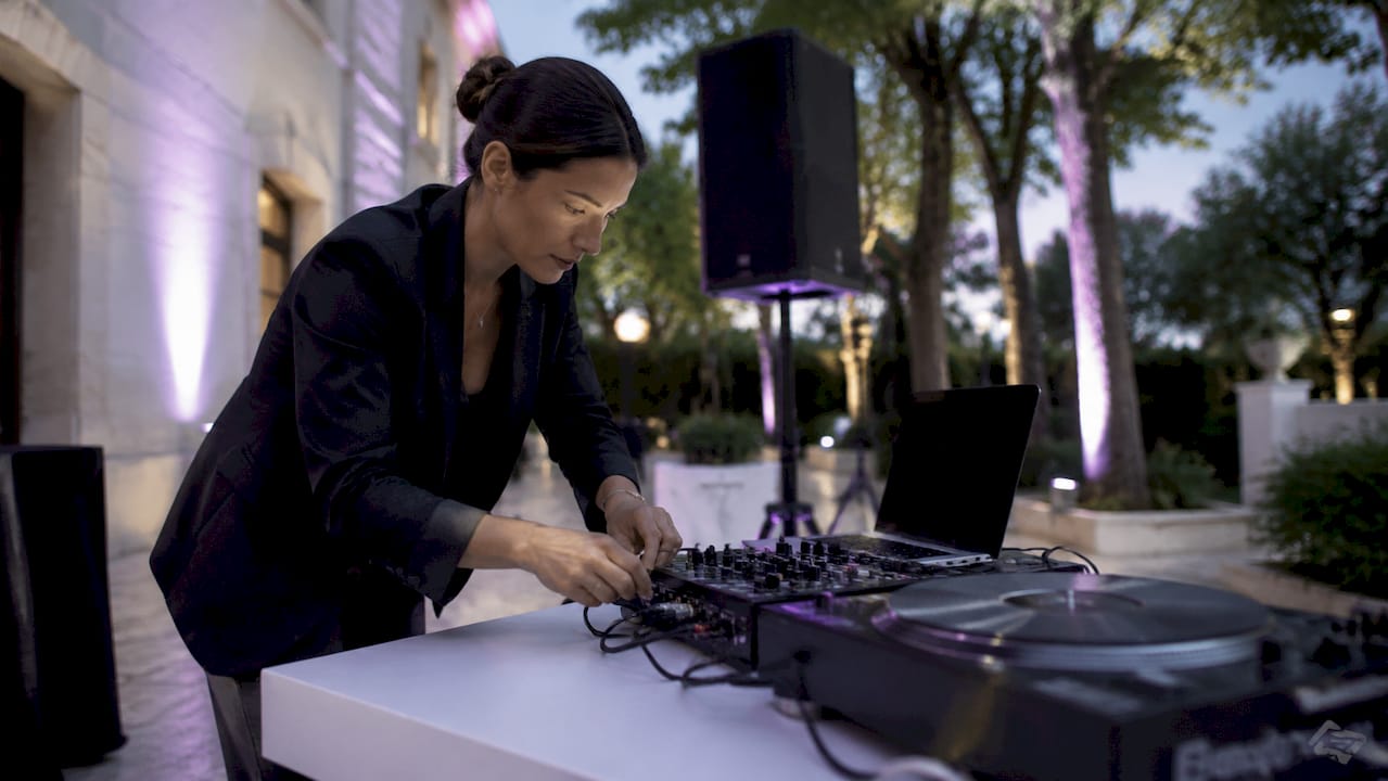 Wedding DJ configuring audio gear outdoors at sunset